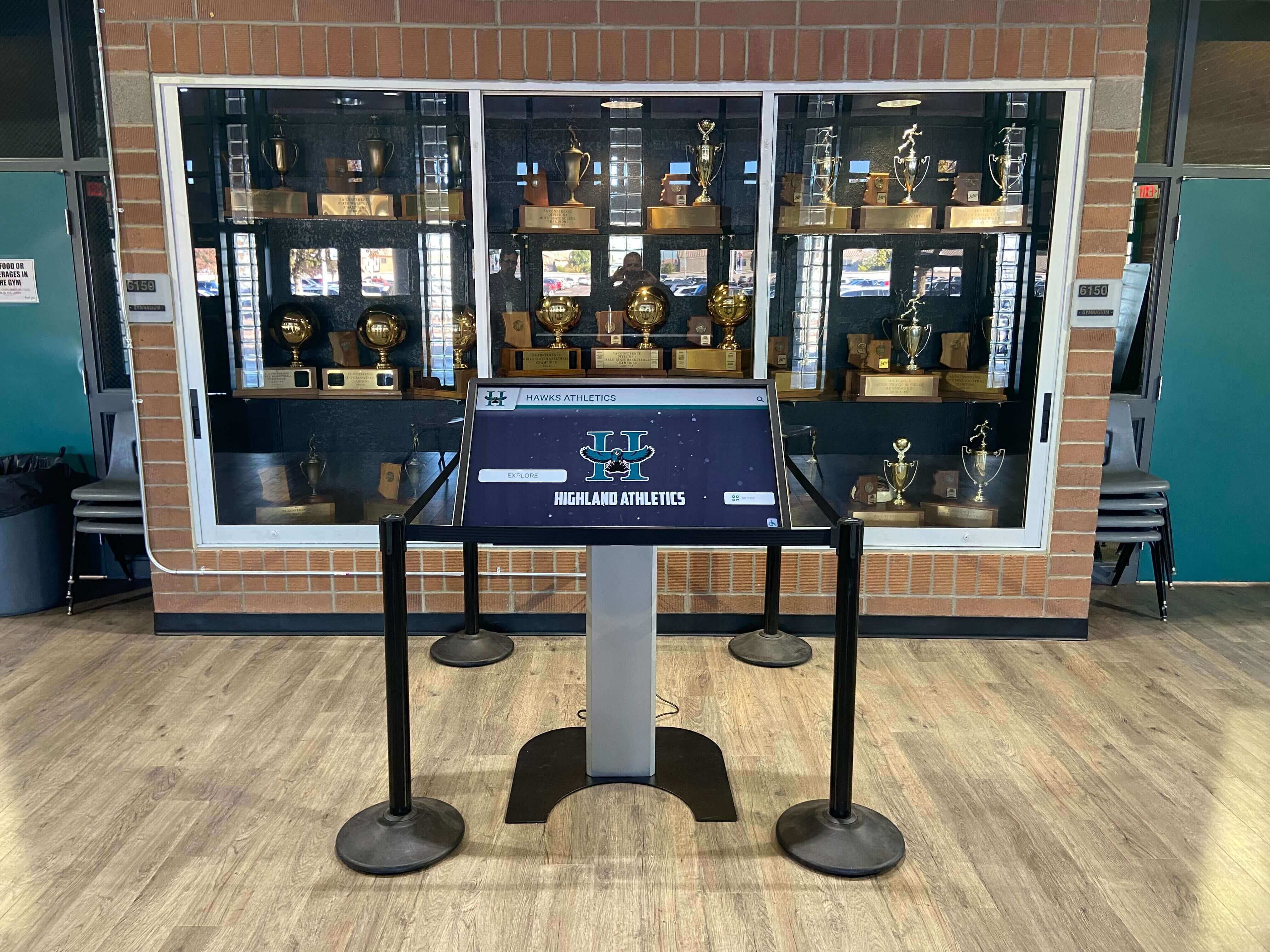 Interactive athletics touchscreen kiosk installed in school trophy case