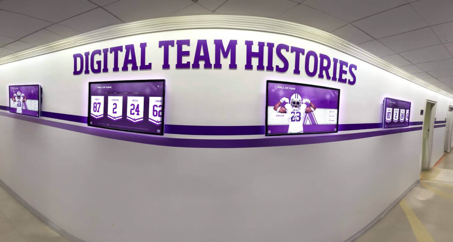 School hallway with purple digital screens displaying team histories